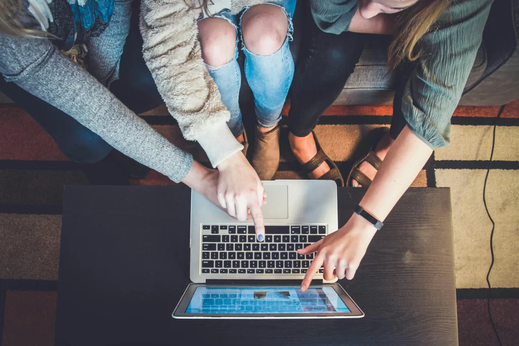 Grupo de pessoas pesquisando cursos de fotografia online em um laptop